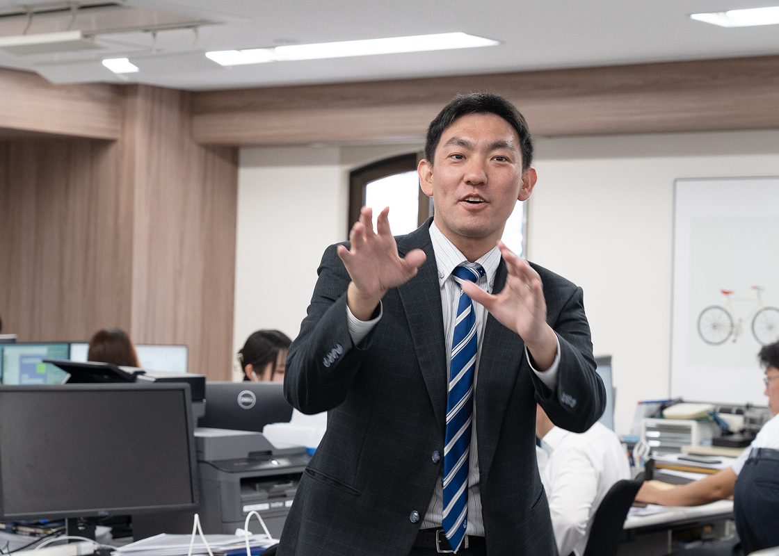 ジェスチャーしながら話す男性社員